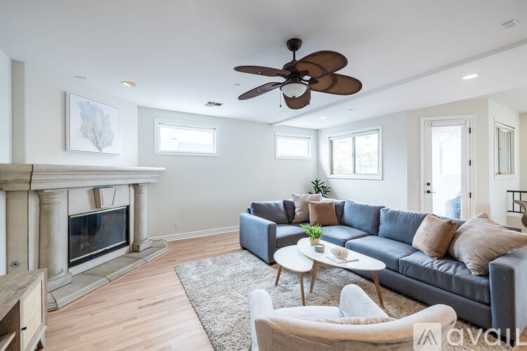 A living room with a fireplace and a grey couch.