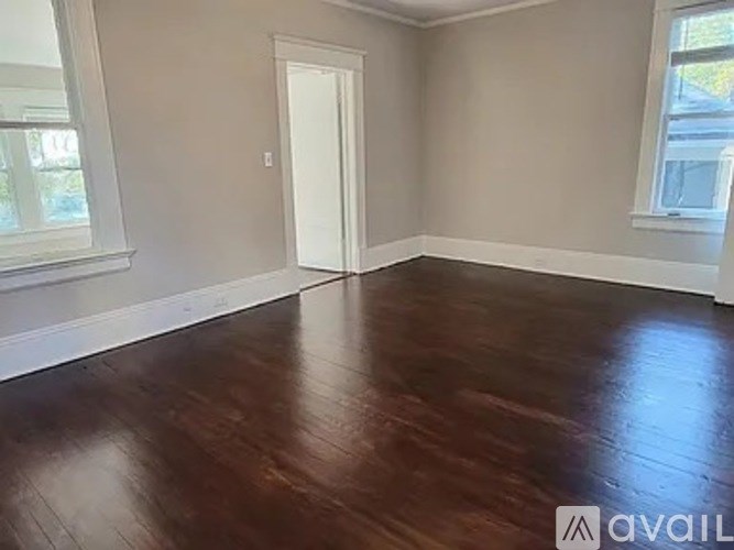 A room with wooden flooring and a white door.