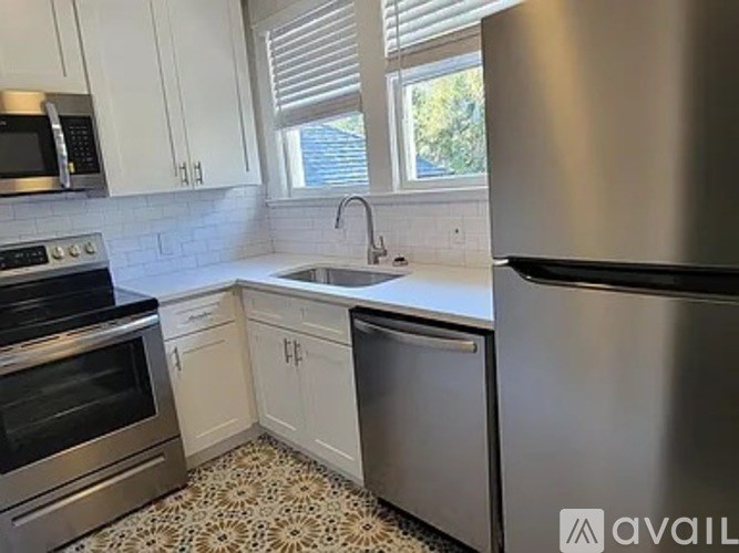 A kitchen with a stainless steel refrigerator, oven, and microwave.