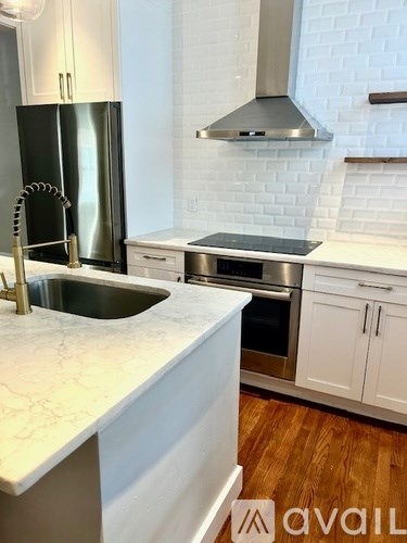 A kitchen with a marble countertop and stainless steel appliances.