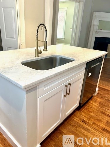 A kitchen with a sink and a marble counter top.
