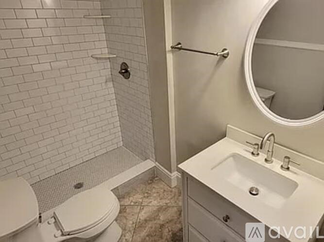 A bathroom with a toilet, sink, and a mirror.