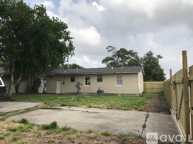 A beige house with a brown fence in front of it.