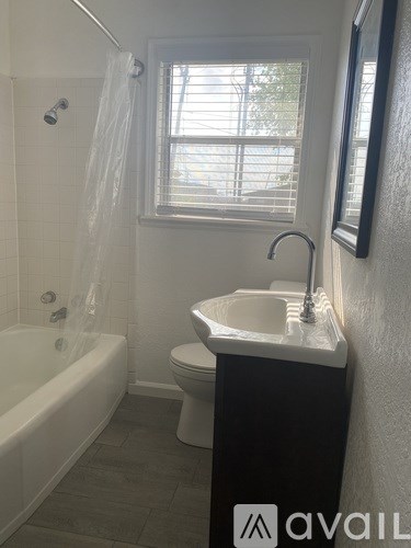 A bathroom with a white tub, toilet, and sink.