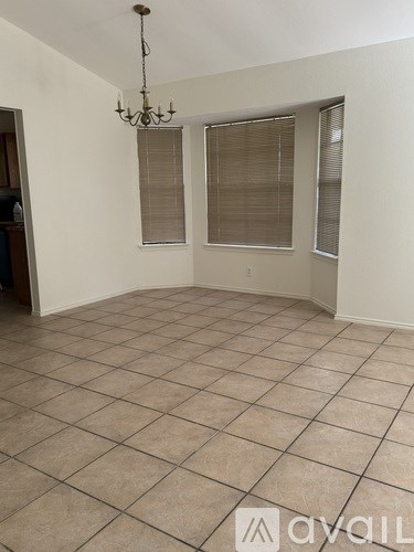 A room with tiled flooring and a chandelier hanging from the ceiling.
