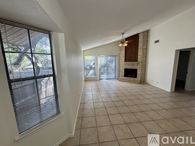 A living room with a fireplace and a ceiling fan.
