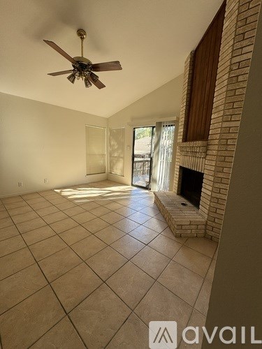 A room with a ceiling fan and tiled flooring.