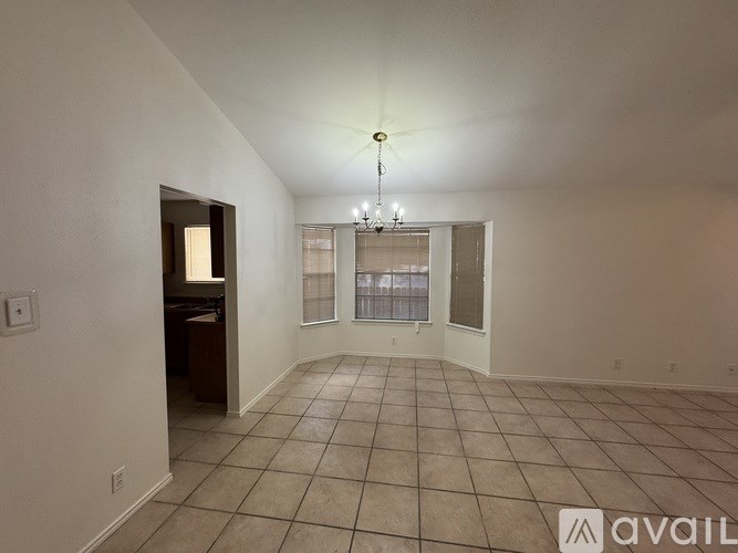 A spacious room with tiled flooring and a ceiling fan.