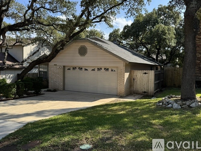 A house with a garage and a tree in front.
