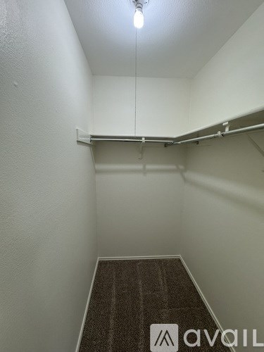 A small, empty room with a carpeted floor and a sign that reads "avail".