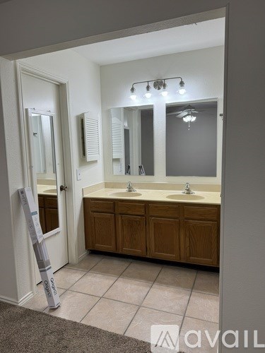 A bathroom with a sink, mirror, and lighting fixture.