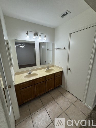 A bathroom with two sinks and a large mirror.