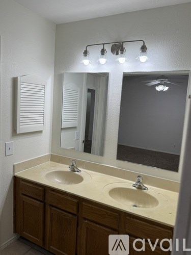 A bathroom with two sinks and a mirror.