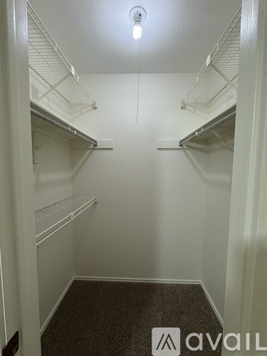 A small walk in closet with a light on.