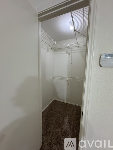 A small, empty room with a carpeted floor and a white wall.