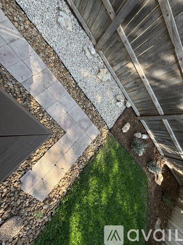 A patio with a stone border and a wooden deck.