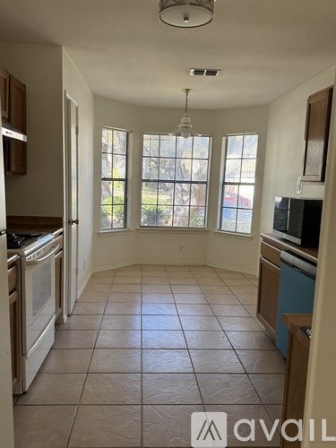 A kitchen with tile flooring and a large window.