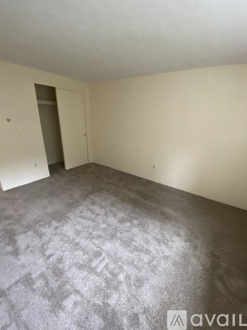 A room with a grey carpet and a white door.