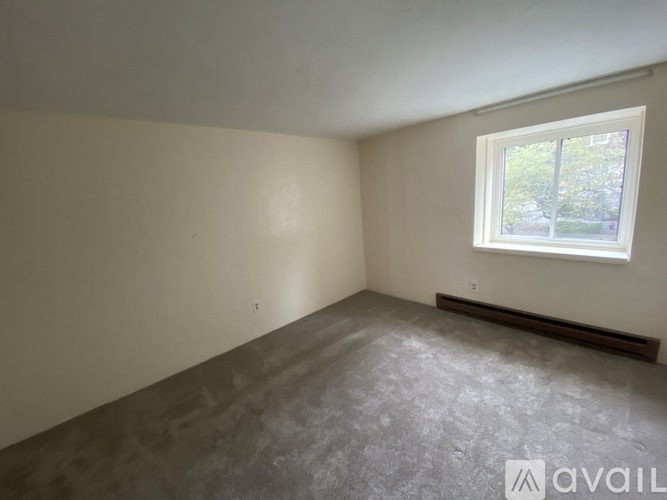 Empty room with a window and a radiator on the wall.