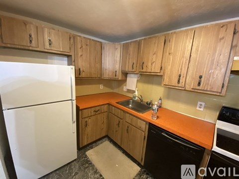 A kitchen with wooden cabinets and a white refrigerator.