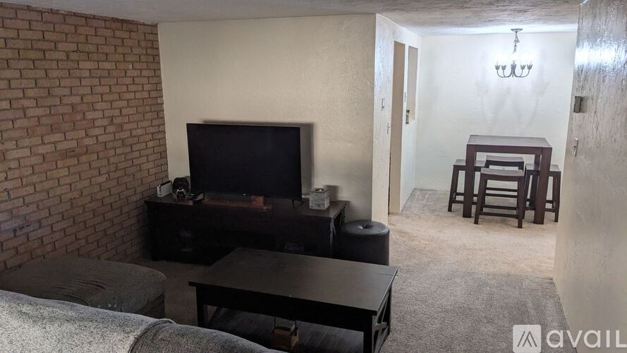 A living room with a brick wall and a television.