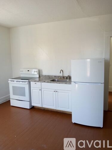 A kitchen with white appliances and cabinets.