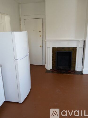 A white fridge in a room with a fireplace.