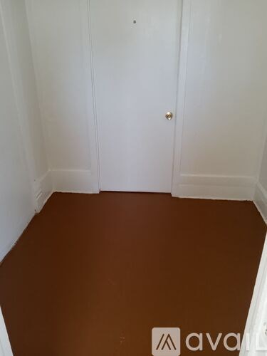 A room with a brown floor and white walls.