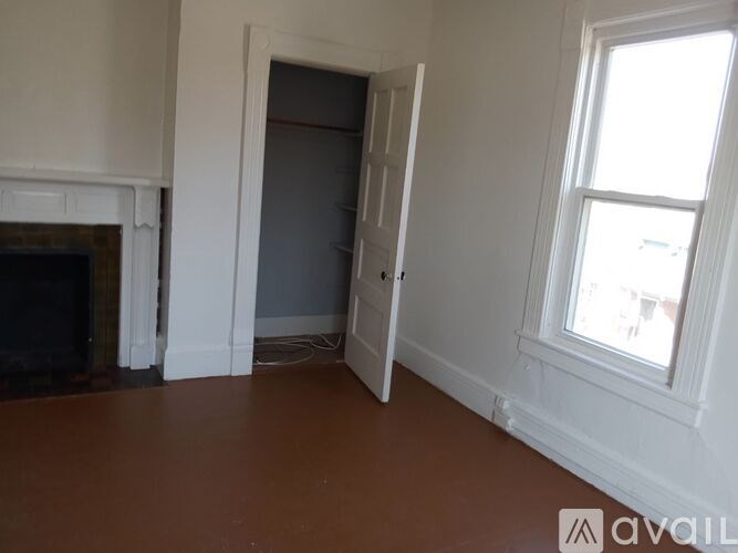 A room with a fireplace and a window.