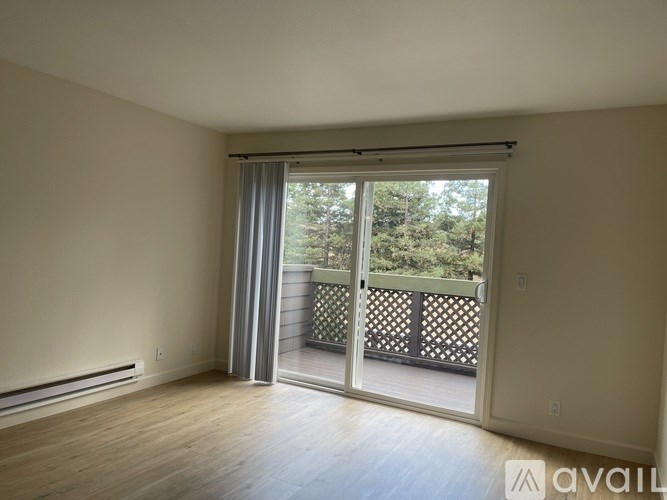 A room with a sliding glass door leading to a balcony.