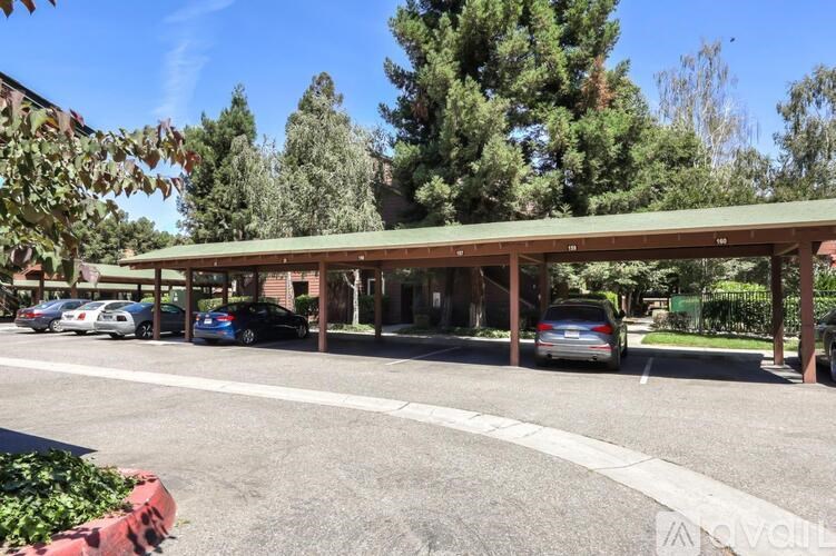 A parking lot with cars and a building in the background.