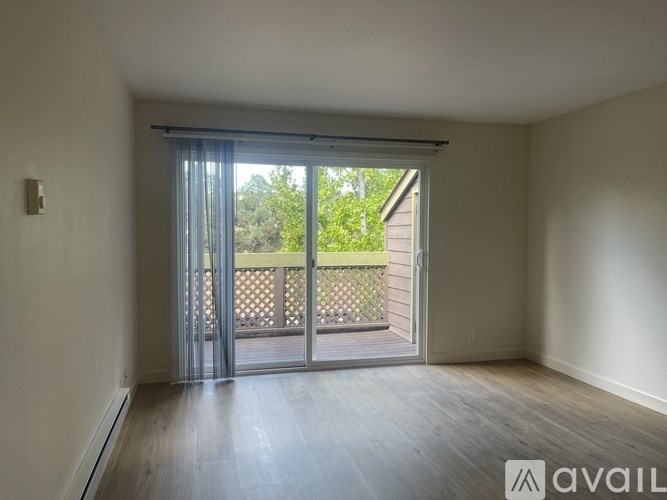 A room with a sliding glass door leading to a balcony.