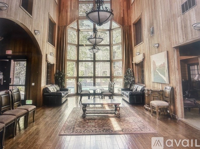 A large, open-plan living area with wooden floors and a large window.