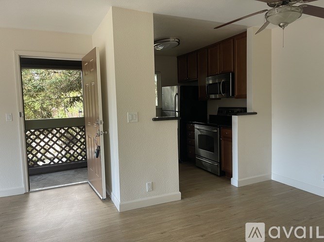 A kitchen with a refrigerator, microwave, and oven.