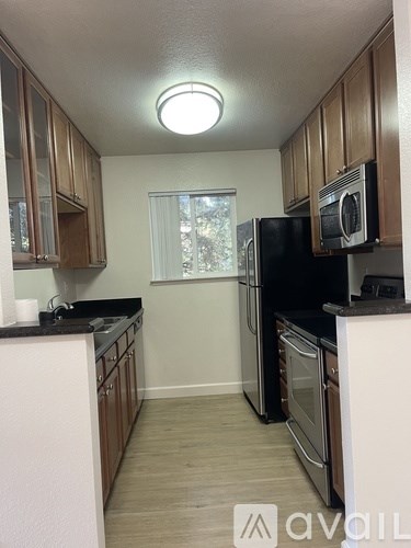 A kitchen with wooden cabinets and black appliances.