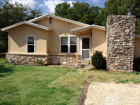 A house with a stone pillar in front of it.