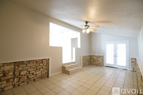 A room with a stone wall and a ceiling fan.