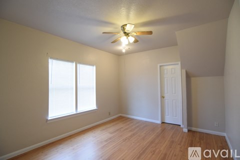 A room with a ceiling fan and a door.