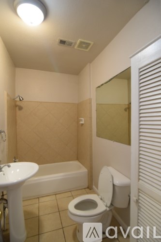 A bathroom with a toilet, sink, and bathtub.