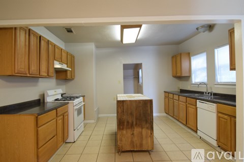 A kitchen with wooden cabinets and a white stove top oven.