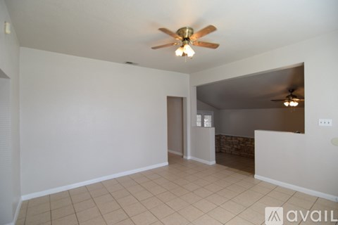 A room with a ceiling fan and tiled floor.