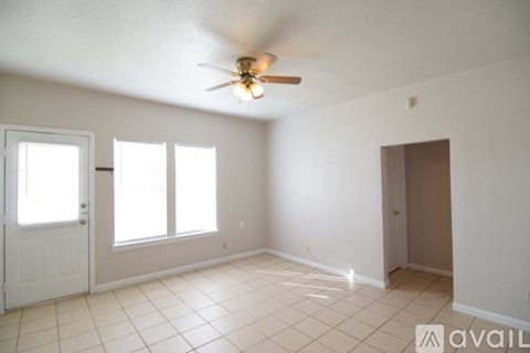A room with a ceiling fan and tiled flooring.