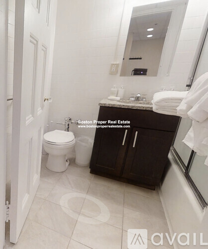 A bathroom with a toilet, sink, and mirror.