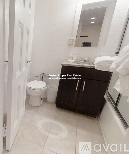 A bathroom with a toilet, sink, and mirror.