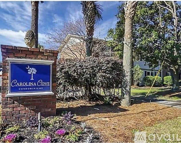 A sign for Carolina Cove Condominiums is shown in front of a building.