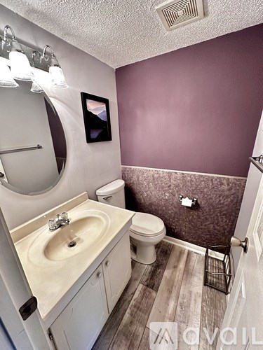 A bathroom with purple walls and a white sink.