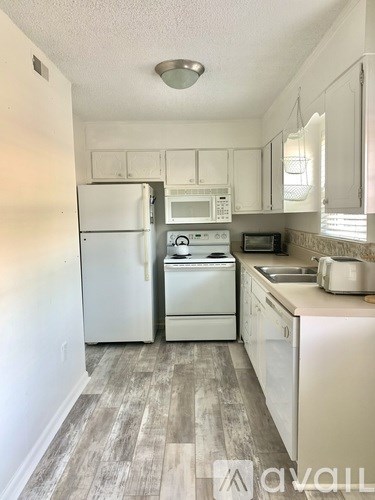 A kitchen with white appliances and cabinets.