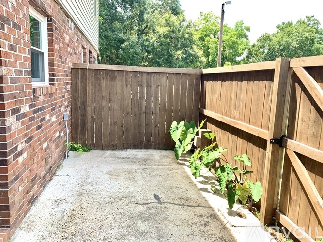 A backyard with a wooden fence and a gravel path.