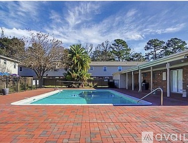 A swimming pool surrounded by a brick patio.