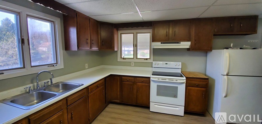 A kitchen with wooden cabinets and a white stove top oven.